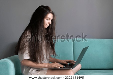 woman working on a laptop and holding it in her hands