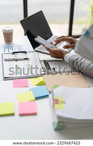 Businessman Preparing reports papers with graphs, charts on Stacks of documents files for finance in office. Piles unfinished achieves with paper clip near computer. Concept of Business Annual Report.
