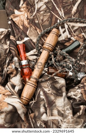 Still life shot of bird calls against camouflage clothing.