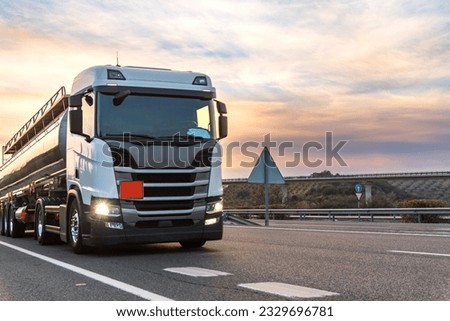 Tanker truck with dangerous goods circulating at sunset. Royalty-Free Stock Photo #2329696781