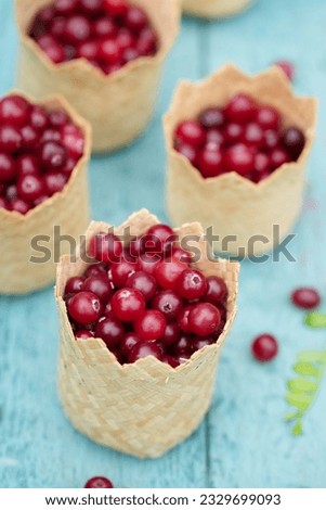 sour berry cranberries in small wicker baskets on a blue background