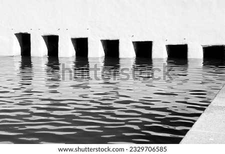 Square openings for the passage of water in a channel . Monochrome picture.