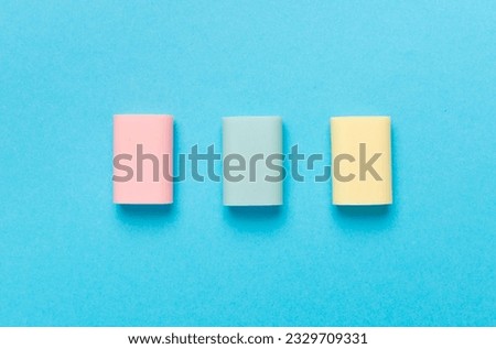 Colorful erasers on color backgroung, top view