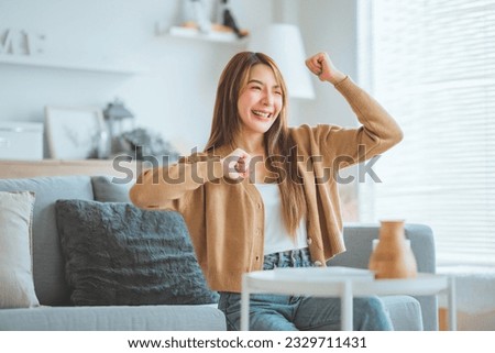 Happy carefree young woman dancing alone having fun at home listening to good music, Female feeling happy to spend leisure time at home and enjoying weekend activity in house Royalty-Free Stock Photo #2329711431