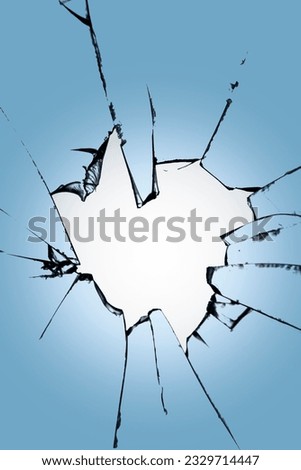 Pieces of broken glass with a hole in the center on a blue background. Texture of cracks on the window. Destruction effect for design