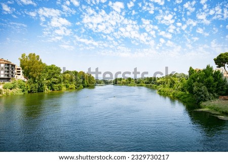 View of the Ebro River at the exit of the city of Tortosa on a bright summer day Royalty-Free Stock Photo #2329730217