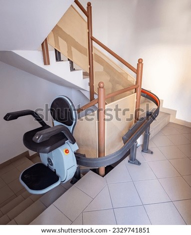 Disabled climbing mobility chair, mobile stair lift helping wheelchair Royalty-Free Stock Photo #2329741851