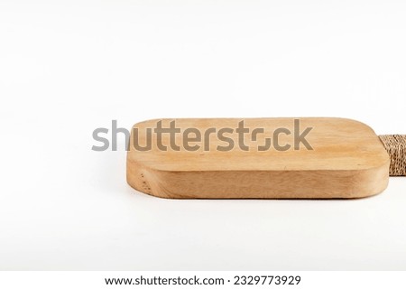 Food preparation tool and kitchen utensils concept with close-up on rectangular wood chopping board with round corners isolated on white background.