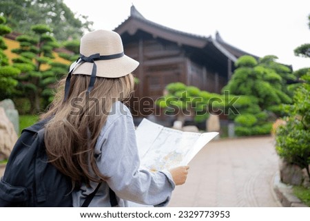 Asian tourist, cute woman with long hair are traveling in Hong Kong along with map and her camera with fun on her holiday, A temple Nan Lian Garden in Hong Kong, concept travel.
