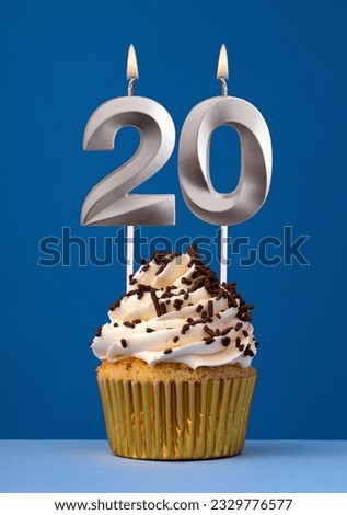 Horizontal birthday card with cake - Lit candle number 20 on blue background Royalty-Free Stock Photo #2329776577