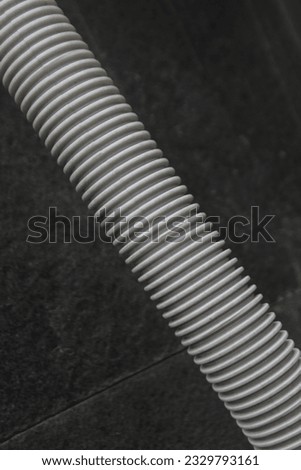 Vacuum cleaner pipe with a dark background that looks like a unique pattern for the background or wallpaper