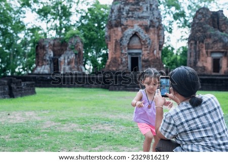 Close-up of mother taking picture of her daughter while enjoying a day in nature.