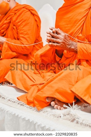 close up monk's hand holding holy thread, buddhist holy day, thai buddhist monk ordination ceremony wallpaper background concept Royalty-Free Stock Photo #2329820835