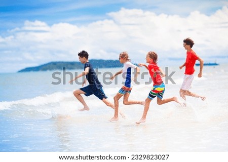 Child playing on tropical beach. Group of boys running at sea shore. Family summer vacation. Travel and camping with kids. Water and sand fun for children. Boy play, build castle on ocean coast