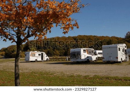 White camper vans parking on camping pitches in autumn