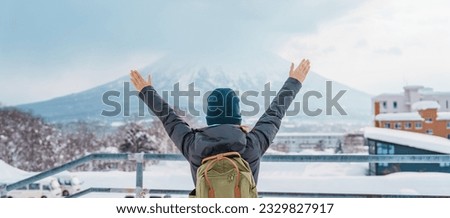 Woman tourist Visiting in Niseko, Traveler in Sweater sightseeing Yotei Mountain with Snow in winter season. landmark and popular for attractions in Hokkaido, Japan. Travel and Vacation concept Royalty-Free Stock Photo #2329827917