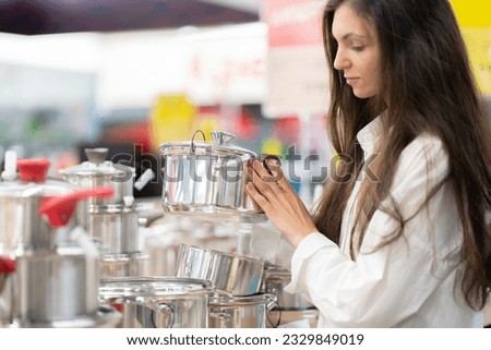 young girl searching for kitchen utensil in the store