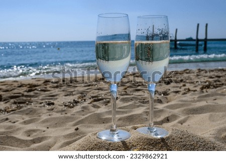 Summer time in Provence, two glasses of cold champagne cremant sparkling wine on famous Pampelonne sandy beach near Saint-Tropez in sunny day, Var department, vanation in France