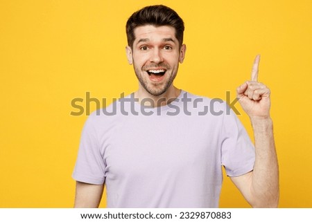 Young insighted happy fun caucasian man he wear light purple t-shirt casual clothes holding index finger up with great new idea isolated on plain yellow background studio portrait. Lifestyle concept