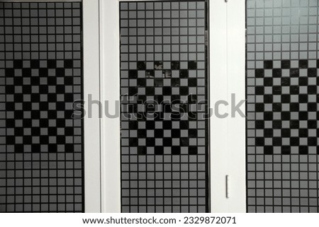 wallpaper on glass in the geometric shape of a chessboard, symmetrical