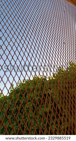 Secure outdoor fence with grid pattern, providing privacy, protection, and design.