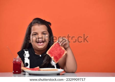 Kid girl eating bread jam stock images