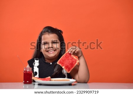 Kid girl eating bread jam stock images