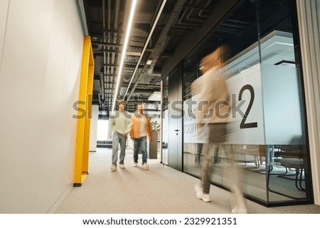 motion blur of modern business people working in corridor along meeting room in contemporary coworking environment with high tech interior, dynamic business concept Royalty-Free Stock Photo #2329921351