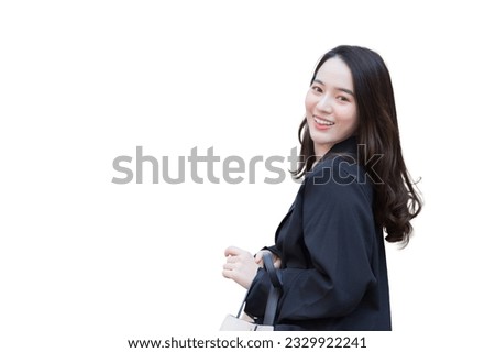 Portrait of a beautiful, long haired Asian woman in black coat walking and smiling while isolated on white background.