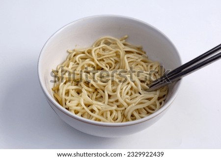Plain instant noodles without topping with in black bowl isolated on white background with clipping path. Asian and Chinese style fast food concept.
