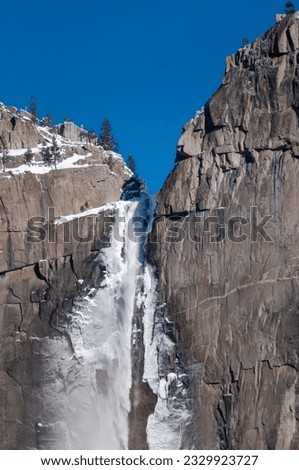 Exterior of the frozen sides of Yosemite Falls, on a snowy, wintery early January morning.