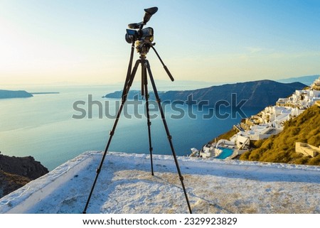 Tripod on observation deck waiting for sunset.Picture taken in Imerovigli village, Santorini,Greece.In the evening there are gorgeous sunset views here and a many photographers waiting for it