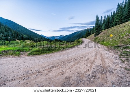 View of green alpine mountains with dirt country rural countryside road to Ophir pass by Columbine lake trail in Silverton, Colorado in summer morning Royalty-Free Stock Photo #2329929021