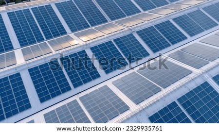 Aerial view of solar roof of the factory in eco environment. Solar Cells panel reflection with the sun and turn to blue color in industrial area. Concept of energy recycle. Royalty-Free Stock Photo #2329935761