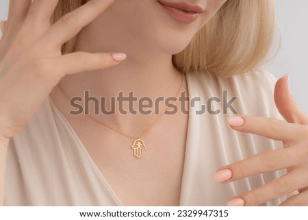 Elegant silver necklace around the neck of a well-groomed lady in a cream blouse. Photos for e-commerce, social media, product sales. Royalty-Free Stock Photo #2329947315