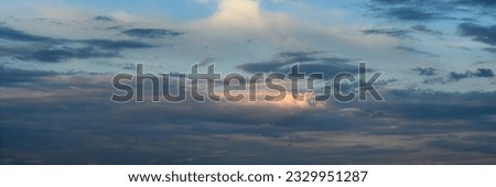 the blue sky below is covered with thick clouds.  widescreen panoramic view.  format 15×5