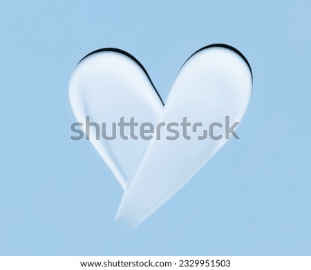 Heart shaped cosmetic smear of cream on a blue background Royalty-Free Stock Photo #2329951503