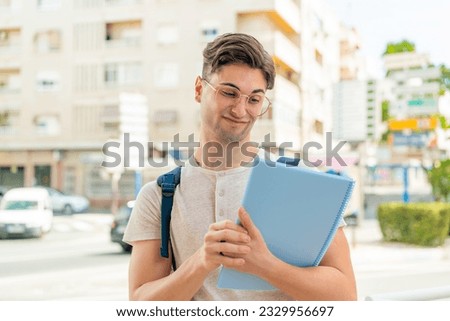 Young handsome student man at outdoors with sad expression