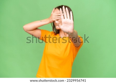 Young pretty caucasian woman over isolated background making stop gesture and covering face