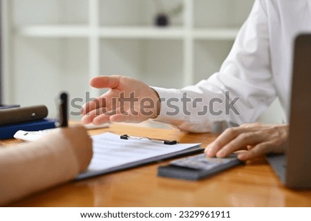Cropped image of male bank manager broker or financial advisor consulting a client at office Royalty-Free Stock Photo #2329961911