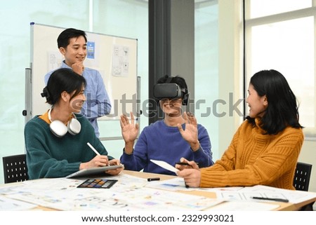 Innovation, technology and futuristic concept. Developers team brainstorming, testing virtual reality simulator glasses at meeting Royalty-Free Stock Photo #2329993021