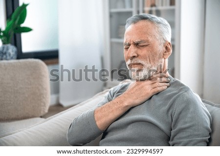 Mature aged man suffering from strong throat sore or angina. Concept of health problems, losing of voice, pain and itching. Elderly person feeling discomfort and difficulty to swallow. Royalty-Free Stock Photo #2329994597