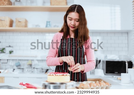 Asian woman as she indulges in her passion for cake making and decoration in the comfort of her lifestyle kitchen, the joy of pursuing one's hobbies