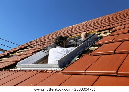 Roofer installs a skylight (Model released) Royalty-Free Stock Photo #2330004735