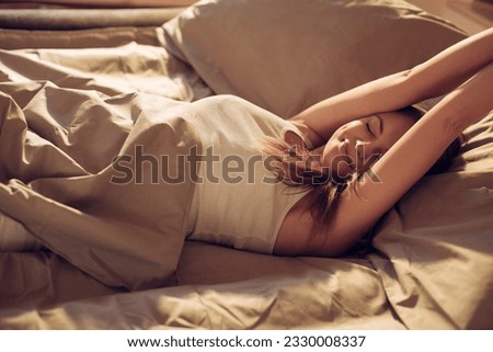 Young woman waking up in the morning in the bed in the bedroom Royalty-Free Stock Photo #2330008337