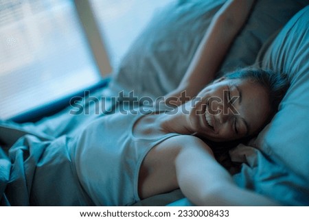 Young woman waking up in the morning in the bed in the bedroom Royalty-Free Stock Photo #2330008433
