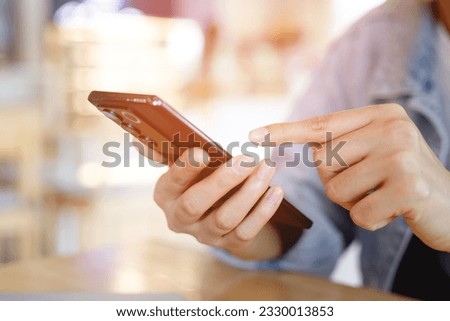 Young man wear plaid shirt.  close up hand using on cell phone during rest on sofa. sitting in watching message on mobile smart phone during break relax. soft focus.