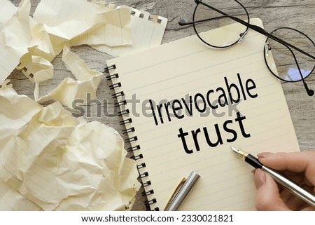 top view of a page with text. woman writes words Irrevocable trust Royalty-Free Stock Photo #2330021821