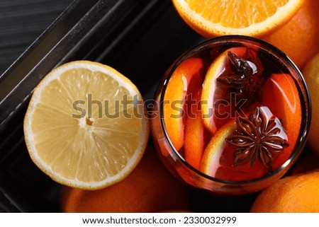 Glass of aromatic punch drink and fresh citrus fruits on table, flat lay