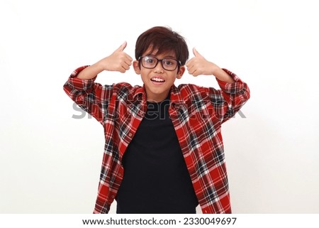Happy asian boy standing while showing thumbs up. Isolated on white